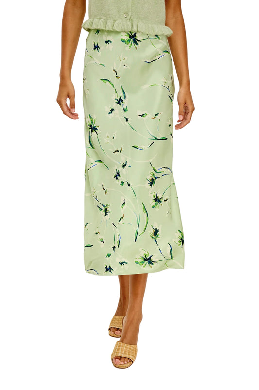 Person wearing a light green floral skirt on a plain background