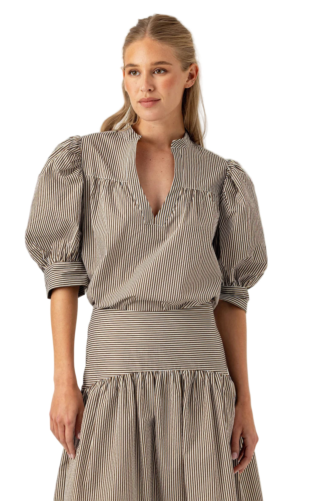 Woman wearing a striped dress with puffed sleeves against a white background