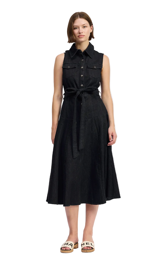 Woman wearing a black sleeveless dress with buttons on a white background