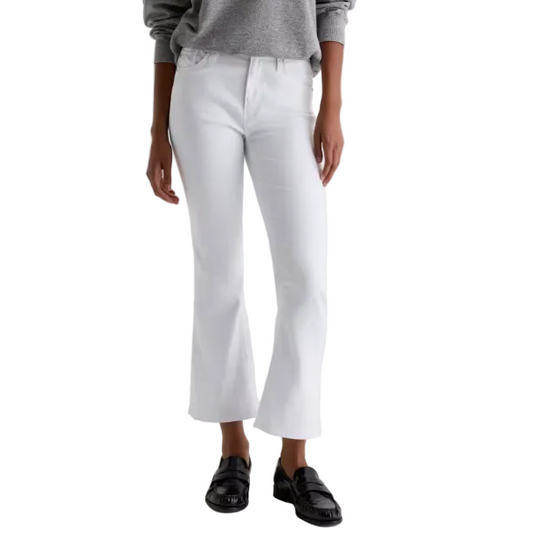 Person wearing white pants and black shoes on a plain background