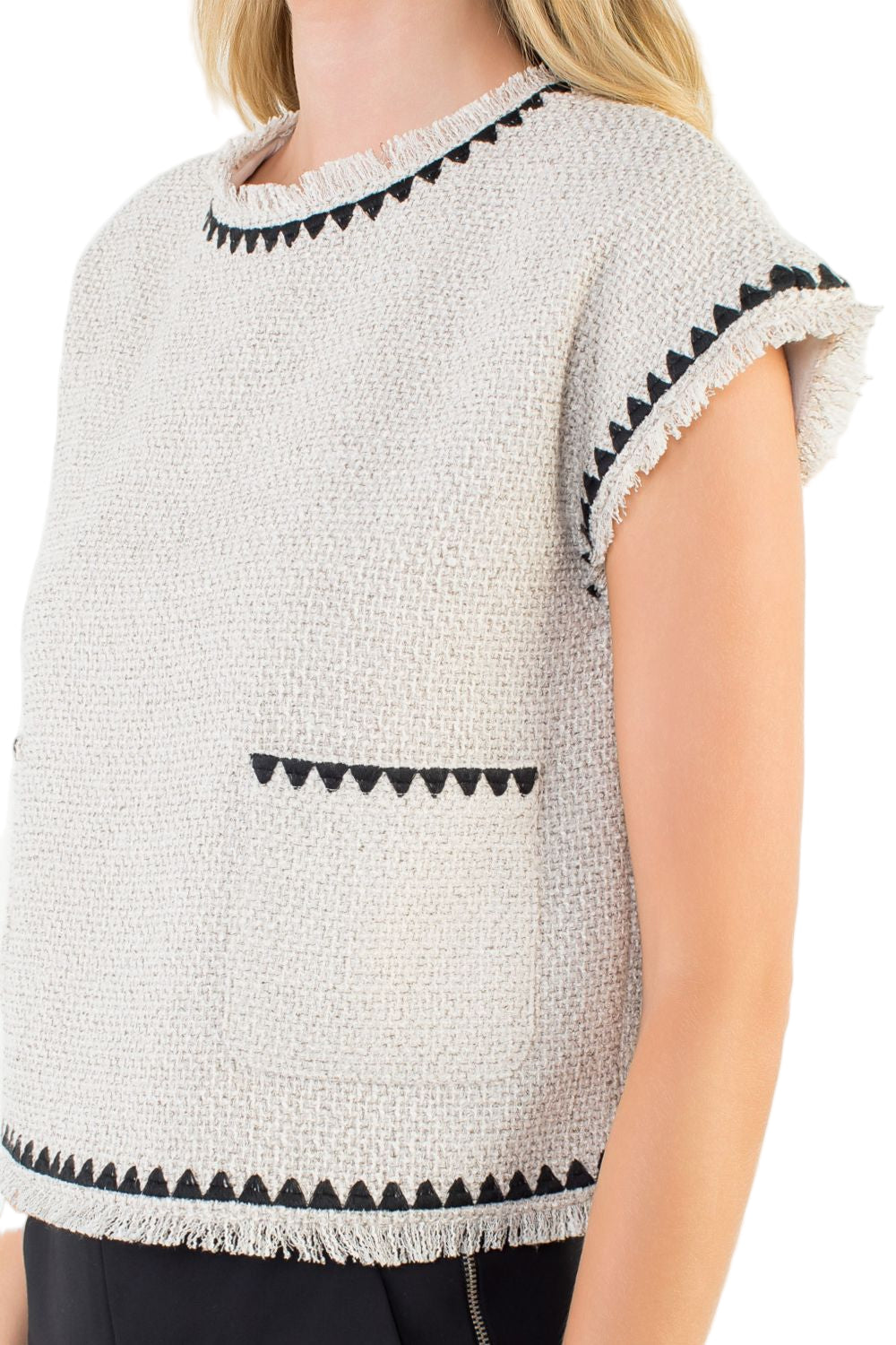Side profile of cream tweed sleeveless top with fringe trim hem