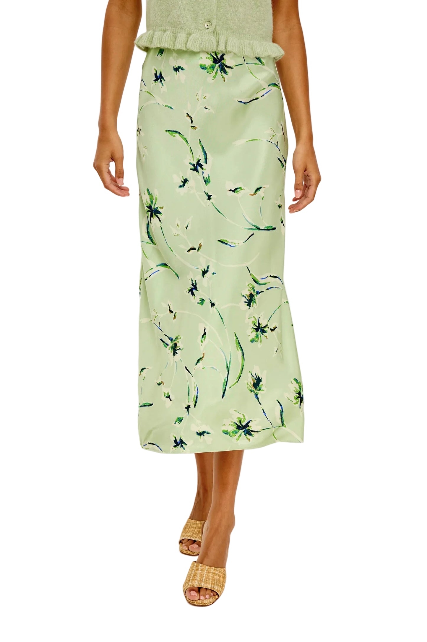 Person wearing a light green floral skirt on a plain background